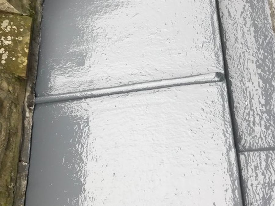 A liquid-coated flat roof between two pitched roofs