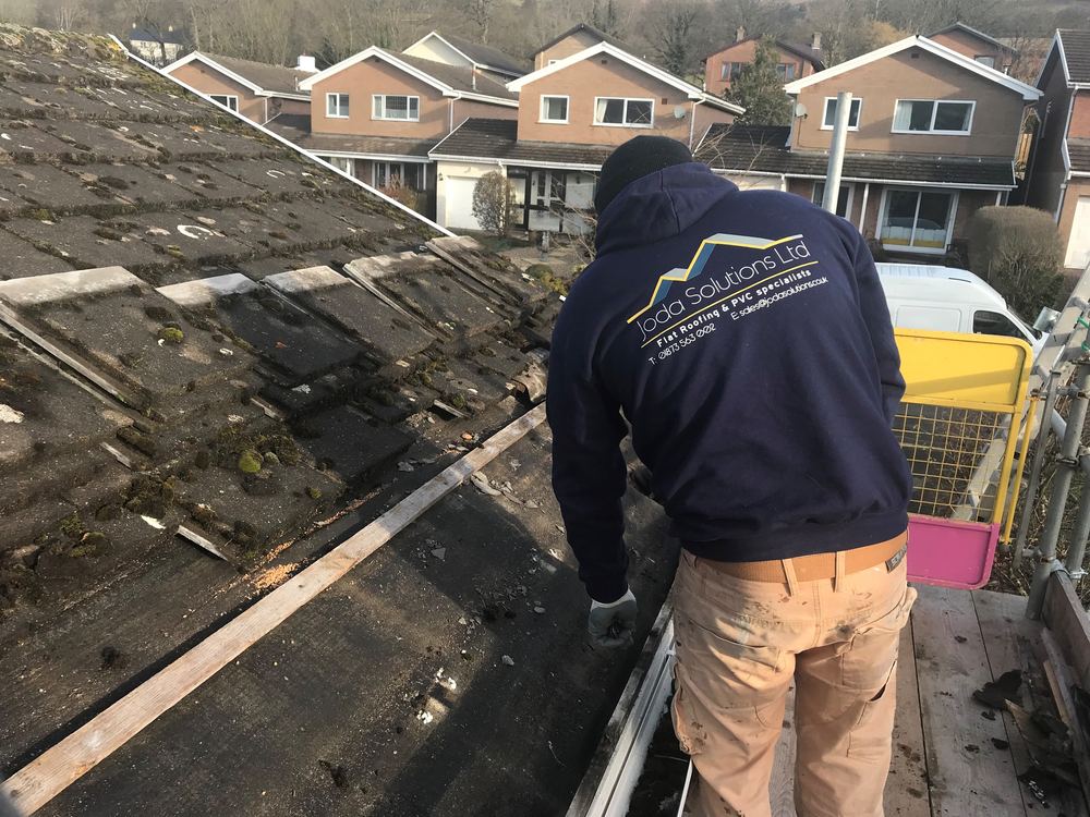 A Joda Solutions roofer working on a stripped roof above Crickhowell