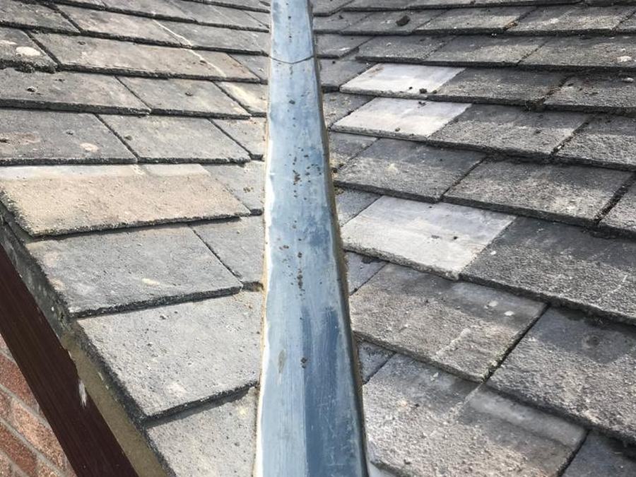 A new lead valley running down a slate roof